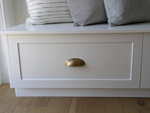 white banquette drawer with bronze shell handle